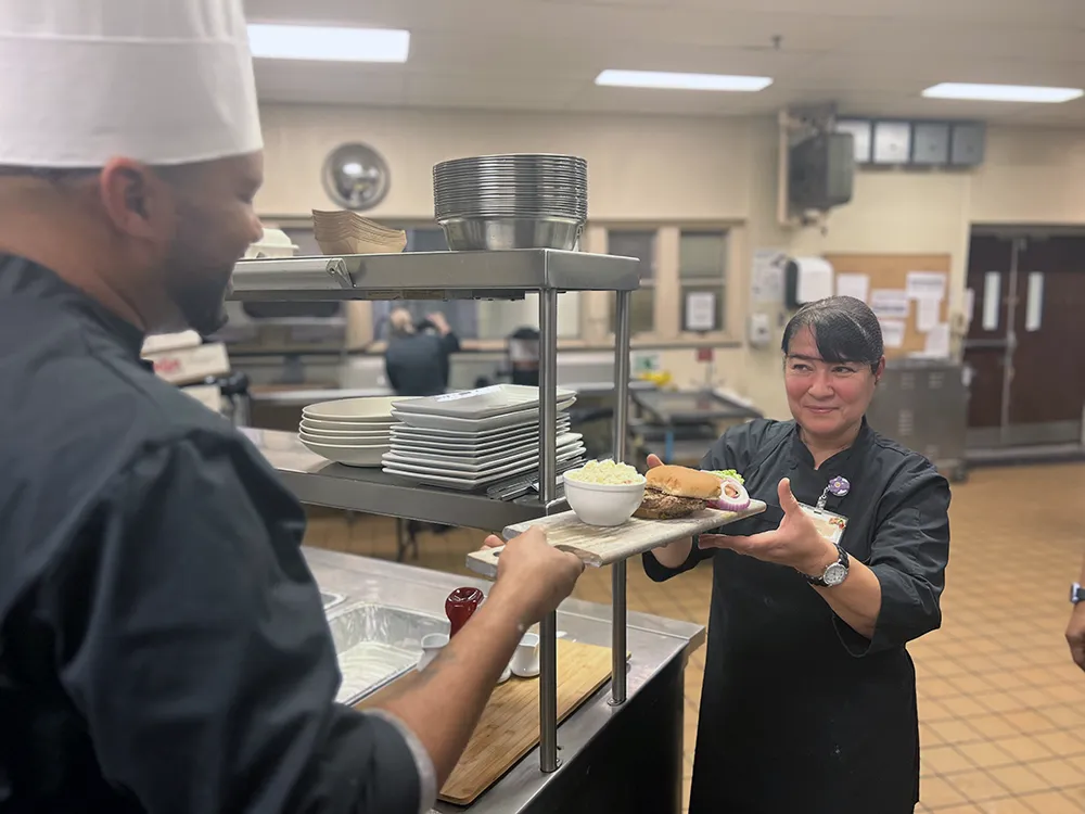 dining staff holding plate of feed