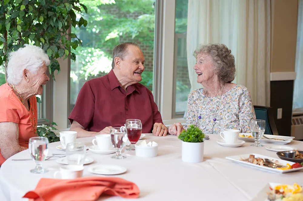 seniors smiling and talking at dinner