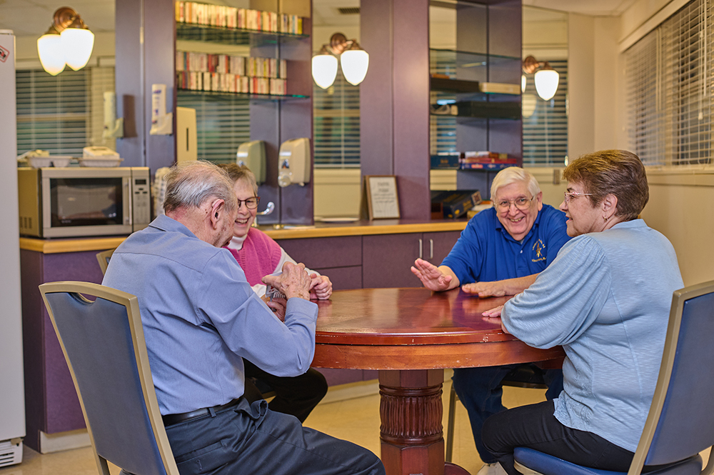 seniors playing cards at a round table